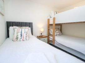A bedroom with a bed and a bunk bed at Dovedale Lodge Troutbeck Bridge