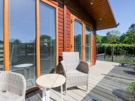 An outdoor seating area with chairs and a table at Dovedale Lodge Troutbeck Bridge