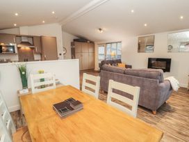 A living room with a sofa and dining area at Dovedale Lodge Bowness 70, White Cross Bay near Windermere