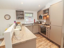 A kitchen with appliances and cabinets at Dovedale Lodge Bowness 70, White Cross Bay near Windermere
