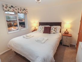 A bedroom with a bed and bedside tables at Dovedale Lodge Bowness 70 White Cross Bay near Windermere