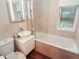 A bathroom with a bathtub and sink at Dovedale Lodge Bowness 70, White Cross Bay near Windermere