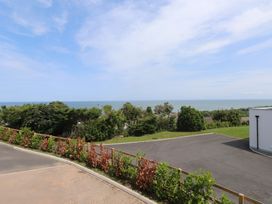 A view of the sea and trees from a property at Golygfa Gele in Llanddulas