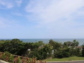 A view of the sea with wind turbines and trees at Golygfa Gele in Llanddulas