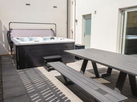 An outdoor area with a hot tub and a dining table at Golygfa Gele Llanddulas