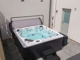 A hot tub with a cover in an outdoor area at Golygfa Gele in Llanddulas