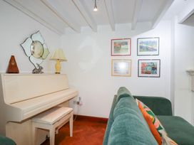 A living room with a piano and paintings on the wall at Rosemaddon in Crantock