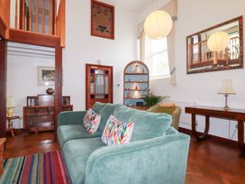 A living room with a teal sofa and bookshelf at Rosemaddon in Crantock