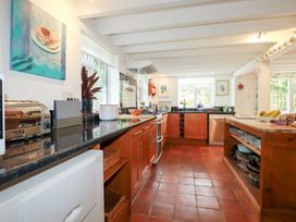 A kitchen with wooden cabinets and appliances at Rosemaddon in Crantock