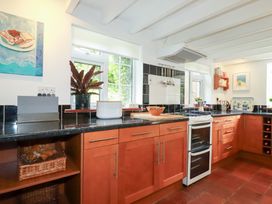 A kitchen with wooden cabinets and black countertop at Rosemaddon in Crantock