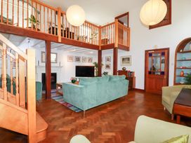 A living room with a staircase and sofa at Rosemaddon in Crantock