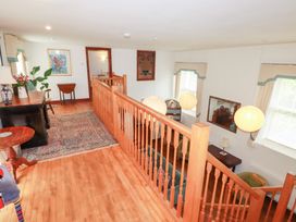 A hallway with a wooden banister and table at Rosemaddon in Crantock