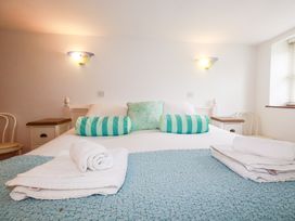 A bedroom with a bed and decorative pillows at Rosemaddon in Crantock