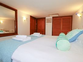 A bedroom featuring a bed with pillows and towels at Rosemaddon in Crantock
