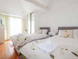 A bedroom with two beds and a television at Rosemaddon in Crantock