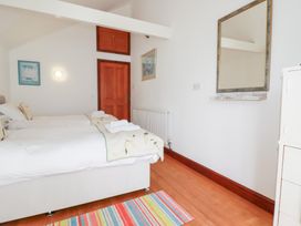 A bedroom with two beds and a mirror at Rosemaddon in Crantock