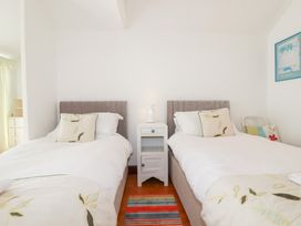 A bedroom with two beds and a bedside table at Rosemaddon in Crantock