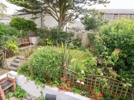 A garden with a bench and plants at Rosemaddon in Crantock