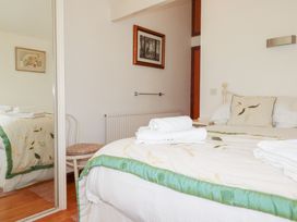 A bedroom with a bed and a chair at Rosemaddon in Crantock