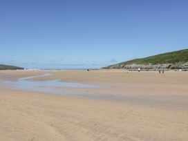 A beach with people walking at Rosemaddon in Crantock