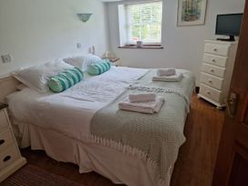 A bedroom with a double bed and a television at Rosemaddon in Crantock
