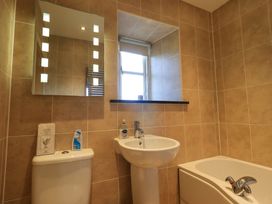 A bathroom with a toilet sink bathtub mirror and a window at Fox Howe in Thornthwaite