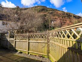 A backyard with wooden fencing and a gate with hills and trees in the background at Fox Howe in Thornthwaite