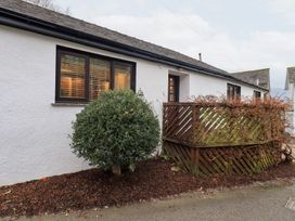 An exterior view of a building with a plant and fence at Jasmine Cottage in Thornthwaite