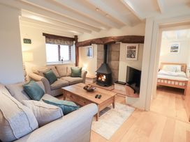 A living room with a fireplace and sofa at Jasmine Cottage in Thornthwaite