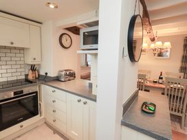 A kitchen with appliances and a dining area at Jasmine Cottage Thornthwaite