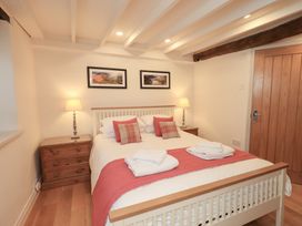 A bedroom with a bed and bedside tables at Jasmine Cottage in Thornthwaite