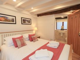 A bedroom with a bed and attached bathroom at Jasmine Cottage Thornthwaite