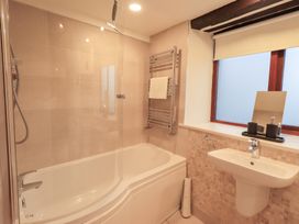 A bathroom with a bathtub and sink at Jasmine Cottage in Thornthwaite