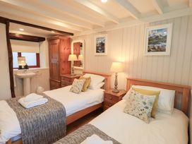 A bedroom with two beds and a washbasin at Jasmine Cottage in Thornthwaite