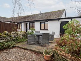 An outdoor seating area with a table and chairs at Jasmine Cottage in Thornthwaite