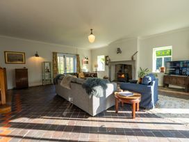 A living room with sofas a woodburner and a television at Coach House in Llanwrtyd Wells