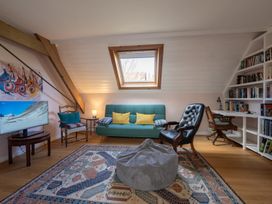 A living room with a sofa a bean bag a television and a bookshelf at Coach House in Llanwrtyd Wells