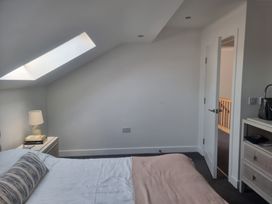 A bedroom with a bed and lamp at Edgemere Cottage in Cartmel