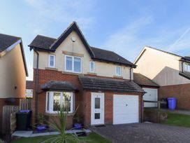 A detached house with brick and cream walls a white garage door and a bay window at Coastal Retreat in Seahouses