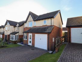 A residential street with two-story houses featuring garages and driveways at Coastal Retreat in Seahouses