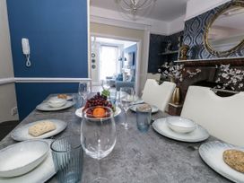A dining table set with plates and fruit at Apartment 1 in Weymouth