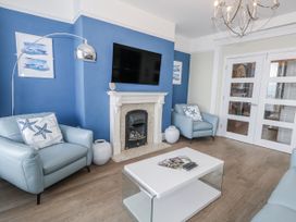 A living room with a television and sofa at Vista Mare 1 in Weymouth