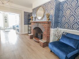 A living room with a fireplace and a mirror at Vista Mare 1 in Weymouth
