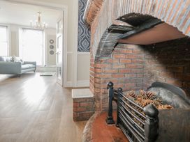 A living room featuring a fireplace with pine cones at Vista Mare 1 in Weymouth