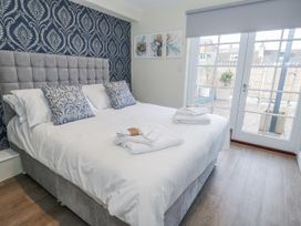 A bedroom with a bed and sliding door at Vista Mare 1 in Weymouth