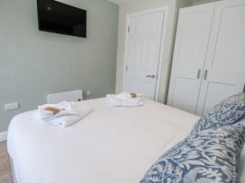 A bedroom with a bed and television at Vista Mare 1 Weymouth
