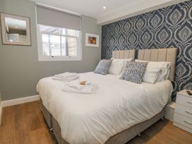 A bedroom with a double bed and wall art at Vista Mare 1 in Weymouth