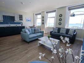 A living room with a coffee table and sofas at Apartment 2 in Weymouth