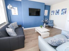 A living room with a sofa and television at Apartment 2 in Weymouth