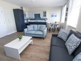 A living room with a sofa and dining area at Apartment 2 in Weymouth